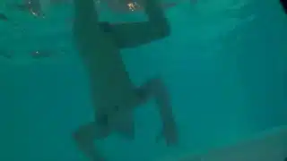 Twink loses trunks in hotel pool and swims naked